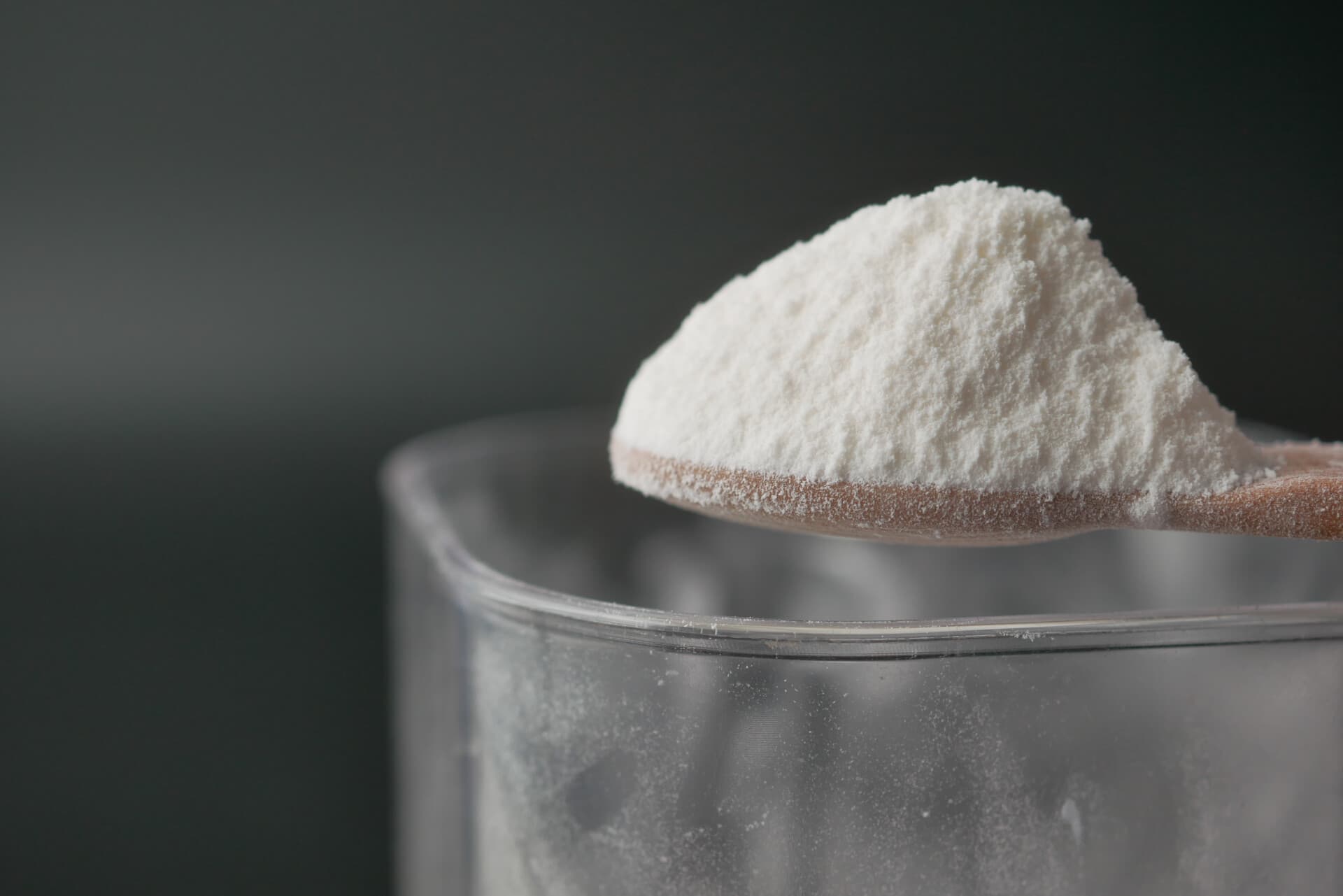 Close-up van wit poeder (baking soda) op een lepel, als huismiddel tegen kalknagels