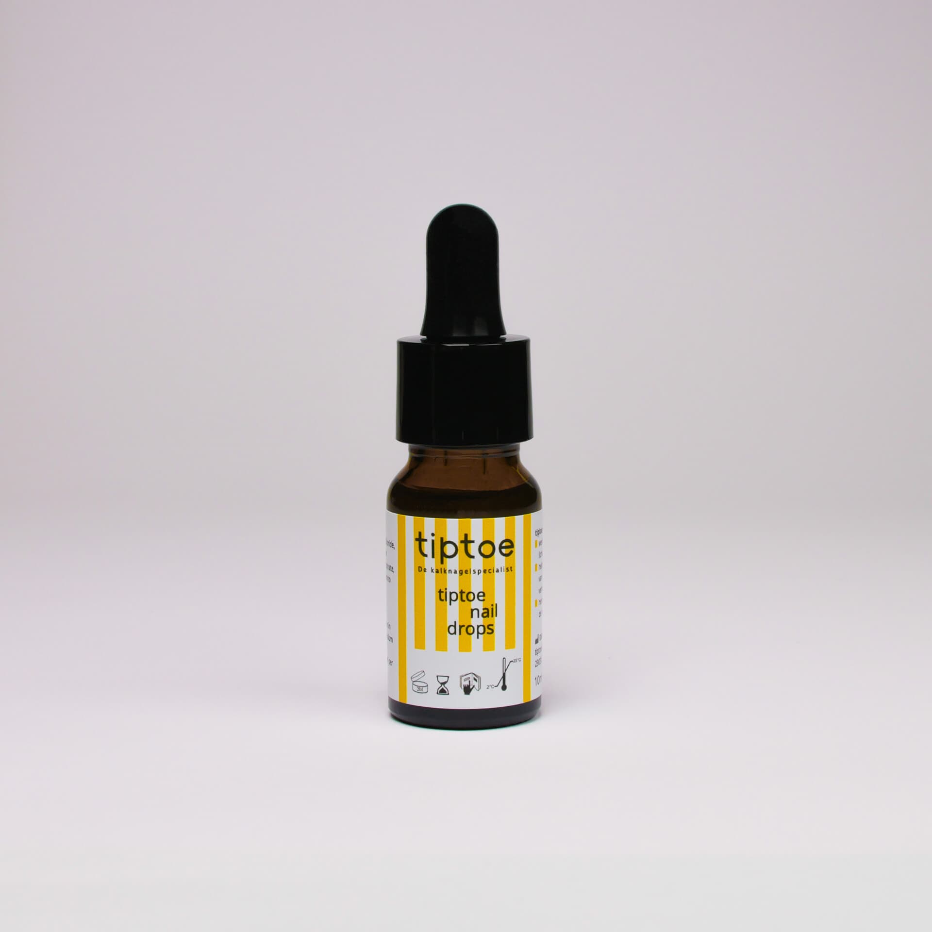 Een flesje tiptoe naildrops met pipetdop, gefotografeerd tegen een lichtgrijze achtergrond, voor de behandeling van schimmelnagels